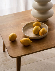Natural ceramic dinnerware set for 4 people with lemons ceramic vase and oak table